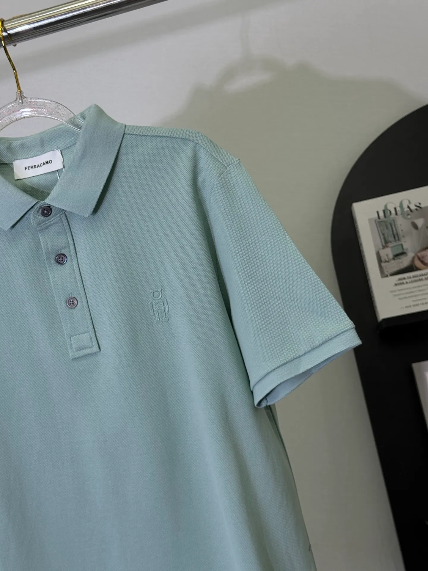 💋 Ferragamo Light Green Robot Logo Polo Shirt puts the avant-garde taste of Italian elegance into this gentle Light Green Polo. The low-key robot logo of the same color on the chest is matched with exquisite brand buttons. The soft Light Green background color is not obvious, but can be recognized by knowledgeable people at a glance. It is a tasteful choice for mature men. We select high-count mercerized pearl cotton, which is draped and wrinkle-resistant. The upper body has a neat and loose feeling. It has a slightly loose fit and is not picky about your figure. It can be easily held in business commuting and light formal occasions. A Light Green Polo can keep you fresh and decent in all spring and summer occasions. M-3XL